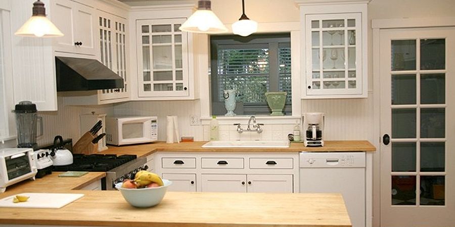 light grey kitchen cabinet with butcher block countertops