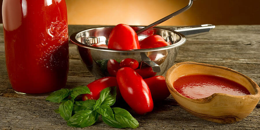 Tomatoes in a hand-crank food mill