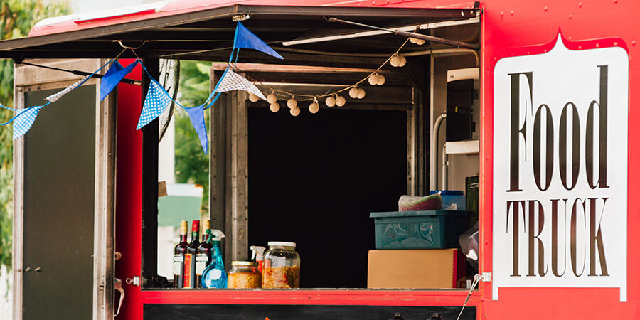 Red food truck kitchen shown with pennants and snacks