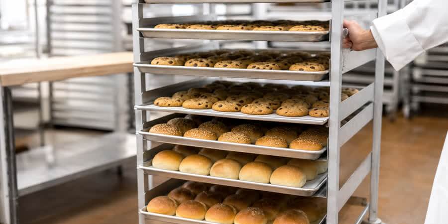 Rolling bun pan rack filled with sheet pans of baked goods